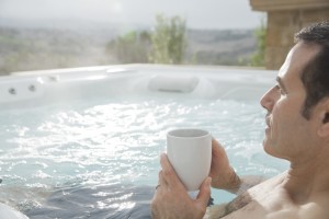 man holding a cup inside a hot tub