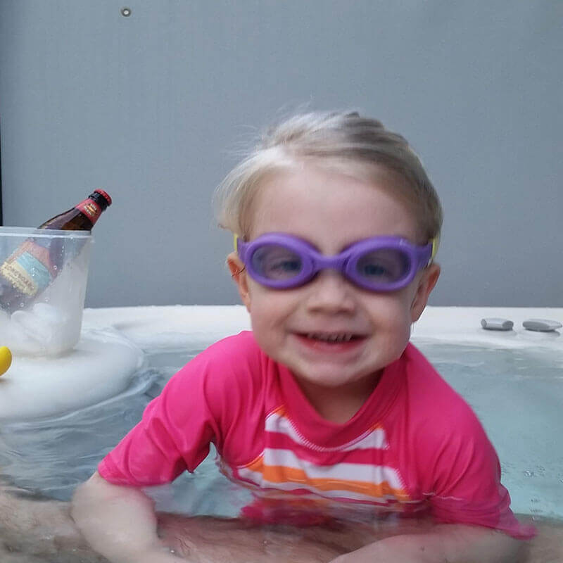 little boy with goggles inside hot tub