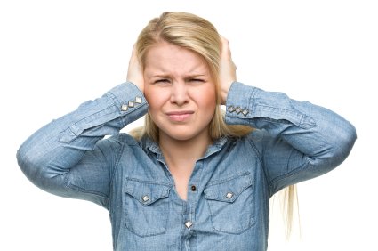 woman blocking ears because of noise