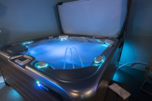 blue-lighted hot tub with waterfall